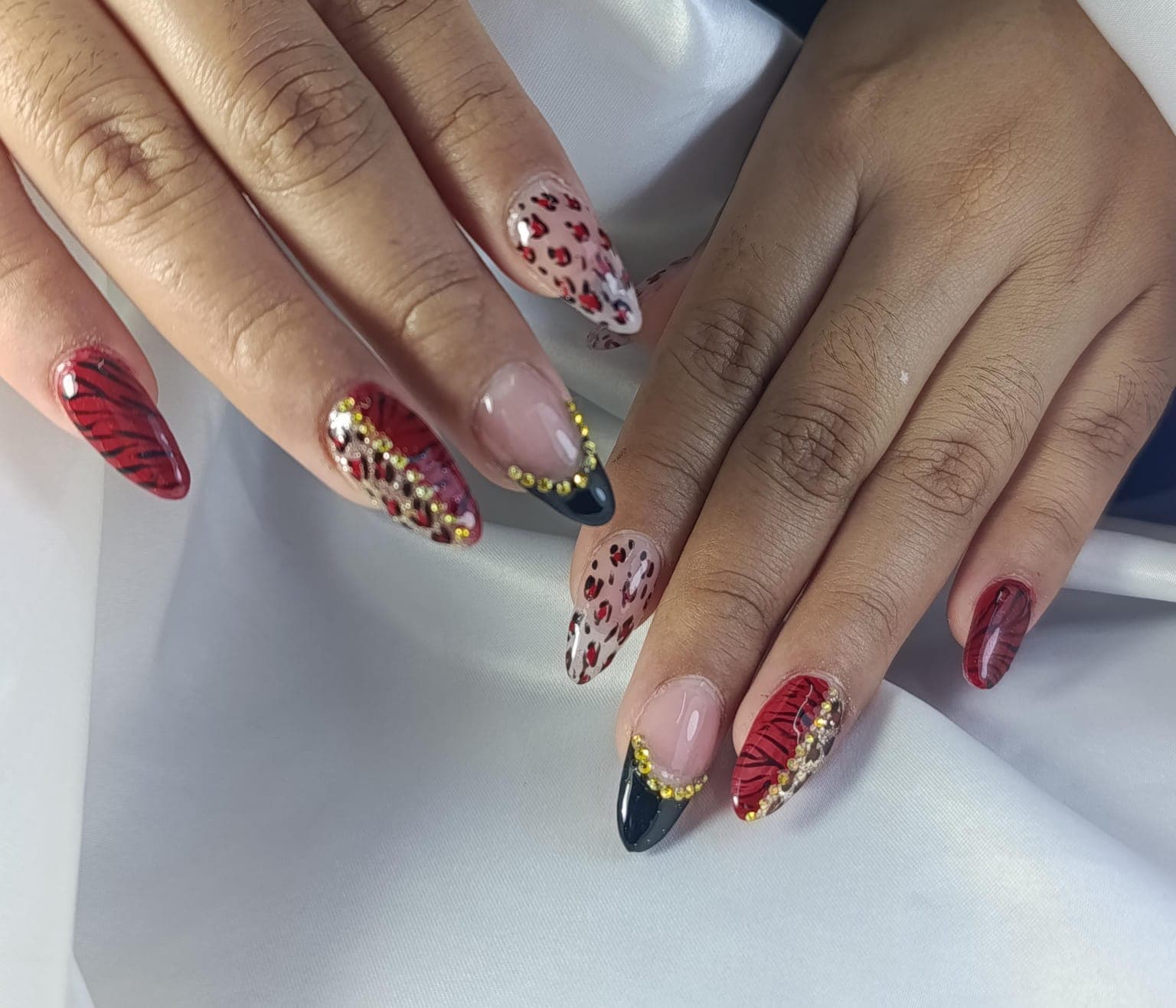 Uñas almendra con animal print rojo y cristales dorados